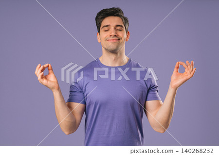 Calm Young Guy Relaxing, Meditating, Refuses Stress. Breathes Deeply On Violet Calm Young Guy Relaxing, Meditating, Refuses Stress. Breathes Deeply On Violet 140268232