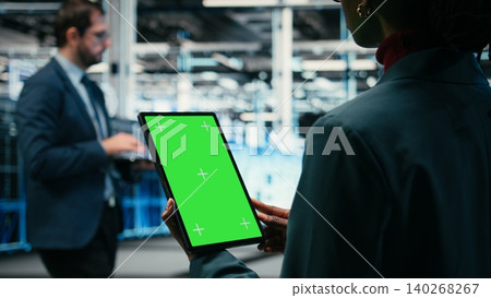 Isolated screen mockup tablet, writing code and software developer in data center. Running programming script, chroma key green screen device application and worker in server hub, camera A 140268267
