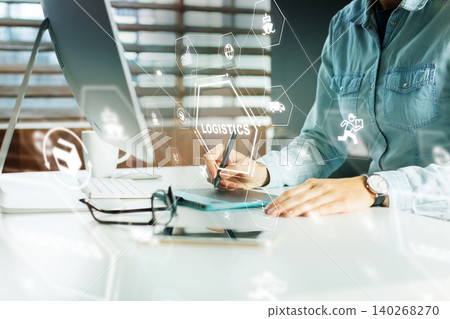 Logistics professional works on a digital tablet in an office setting Logistics professional works on a digital tablet in an office setting 140268270