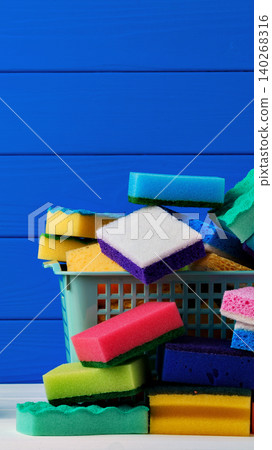 Sponge collection on a table with a blue background and storage basket 140268316
