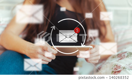 Checking messages on a mobile device while relaxing at home in the afternoon Checking messages on a mobile device while relaxing at home in the afternoon 140268352