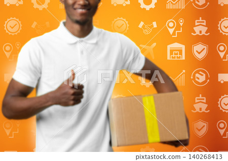 Smiling worker holding a box in front of logistics themed background during daytime Smiling worker holding a box in front of logistics themed background during daytime 140268413