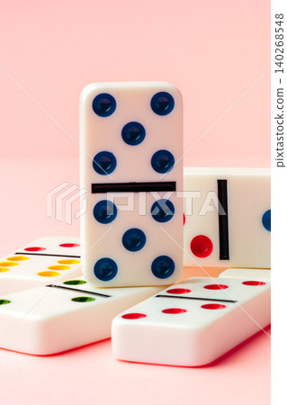Dominoes arranged on a pink background for a game night with friends and family Dominoes arranged on a pink background for a game night with friends and family 140268548