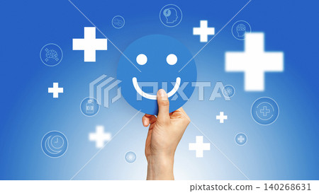 Holding a smiley face icon with health symbols in the background Holding a smiley face icon with health symbols in the background 140268631