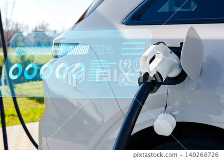 Electric car charging at a station during the day with display of battery level Electric car charging at a station during the day with display of battery level 140268726