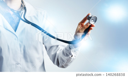 Doctor holds stethoscope in a medical setting during a consultation or examination Doctor holds stethoscope in a medical setting during a consultation or examination 140268838