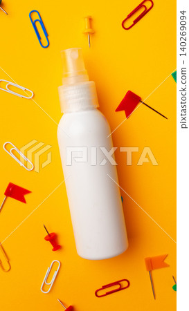 White spray bottle with office supplies on yellow background layout White spray bottle with office supplies on yellow background layout 140269094