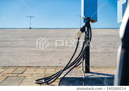 Electric car charger station in empty parking lot on clear day Electric car charger station in empty parking lot on clear day 140269214