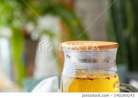 Tea pot of herbal tea on a wooden table close up Tea pot of herbal tea on a wooden table close up 140269243