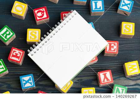 Notepad on wooden table and wood alphabet blocks Notepad on wooden table and wood alphabet blocks 140269267