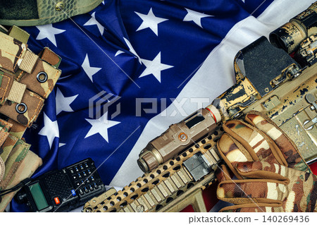 U.S. battle flag and assault rifle on the wooden table. U.S. battle flag and assault rifle on the wooden table. 140269436