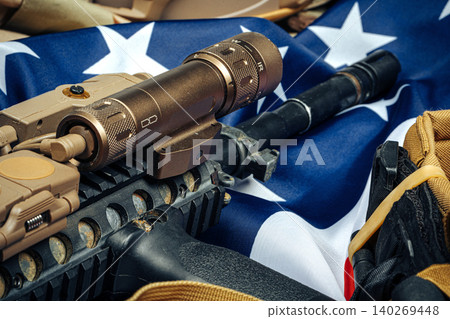 U.S. battle flag and assault rifle on the wooden table. U.S. battle flag and assault rifle on the wooden table. 140269448