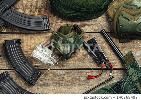 Close up of airsoft gun magazine and airsoft balls on wooden background 140269492