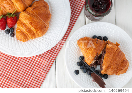 Fresh croissant decorated with berries on white wooden board 140269494