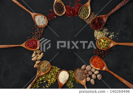 Wooden spoons with various spices on black background 140269496