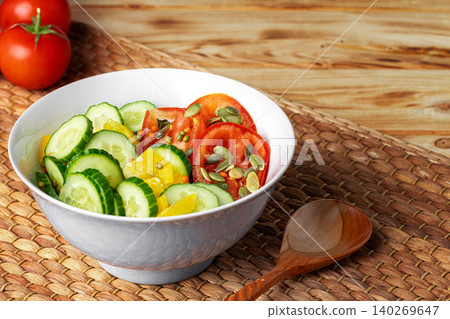 Ceramic bowl of tomato and cucumber salad on table Ceramic bowl of tomato and cucumber salad on table 140269647