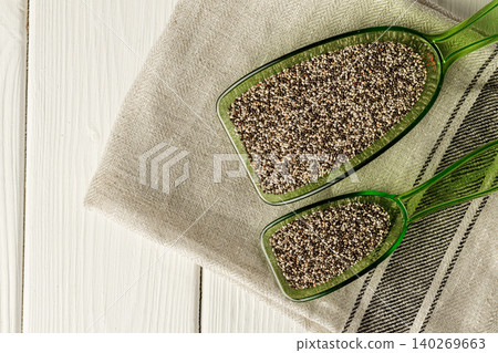 Chia seeds in green plastic scoop on table 140269663