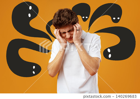 Man holds his head in distress with dark shapes behind him on an orange background Man holds his head in distress with dark shapes behind him on an orange background 140269683