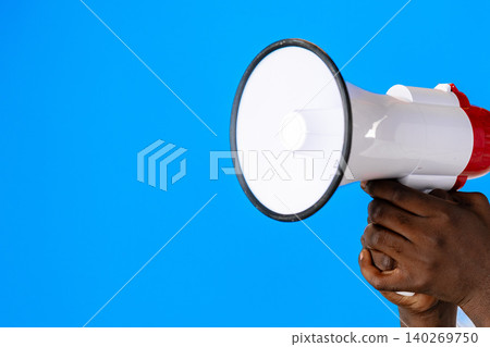 Holding a megaphone against a blue background for a public announcement activity 140269750