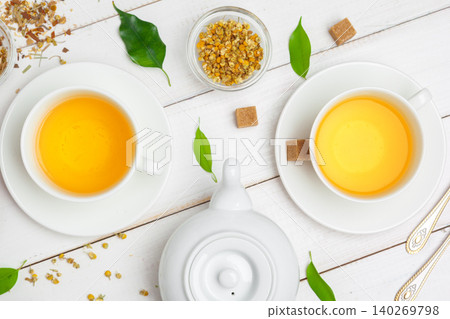 teapot and cups of tea on a white wooden background teapot and cups of tea on a white wooden background 140269798