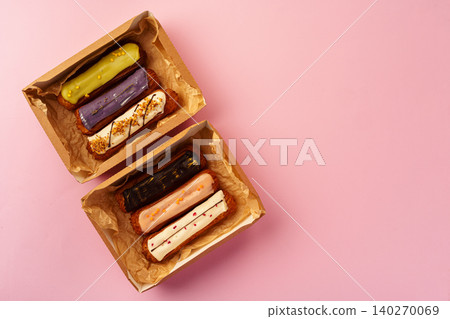 Box with fresh eclairs on pink background Box with fresh eclairs on pink background 140270069