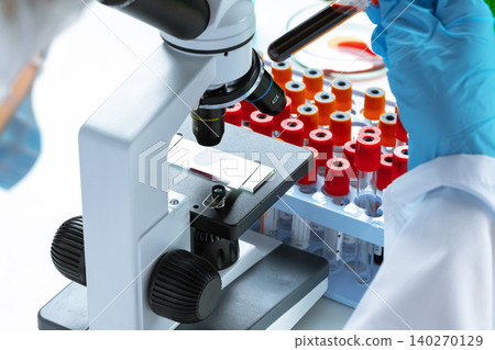Scientist's hands doing chemical research with the help of microscope Scientist's hands doing chemical research with the help of microscope 140270129