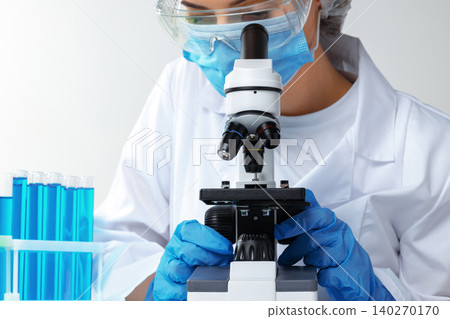 Woman scientist looking through a microscope in laboratory Woman scientist looking through a microscope in laboratory 140270170