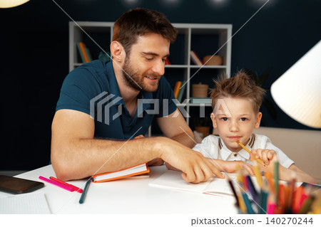 Father helping his little son with school homework Father helping his little son with school homework 140270244