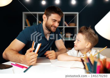 Father helping his little son with school homework Father helping his little son with school homework 140270260