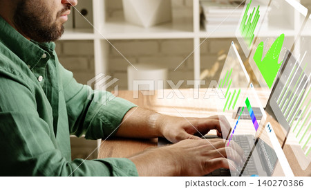 Working with digital business chart tools on a laptop at a desk in a modern office 140270386
