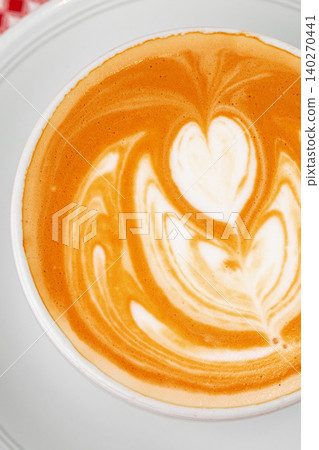Latte art in a white cup with a heart design and warm brown tones Latte art in a white cup with a heart design and warm brown tones 140270441
