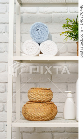 Towels and baskets arranged on a shelf in a bathroom setting Towels and baskets arranged on a shelf in a bathroom setting 140270446