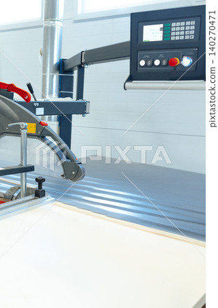 Cutting tool in use on a work table inside a manufacturing facility during daylight hours Cutting tool in use on a work table inside a manufacturing facility during daylight hours 140270471