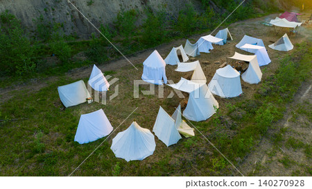 aerial view medieval fantasy camp settlement of white tents and a central campfire under warm sun shine top drone panorama country side aerial view medieval fantasy camp settlement of white tents and a central campfire under warm sun shine top drone panorama country side 140270928