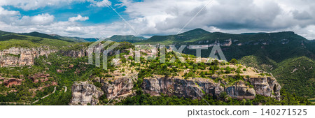 Aerial panoramic view of Siurana village perched on dramatic cliffs surrounded by rugged mountains and deep valleys in Catalonia, Spain. Aerial panoramic view of Siurana village perched on dramatic cliffs surrounded by rugged mountains and deep valleys in Catalonia, Spain. 140271525