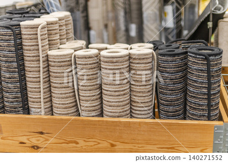 Rolled carpet runners and striped floor mats in home improvement store display Rolled carpet runners and striped floor mats in home improvement store display 140271552