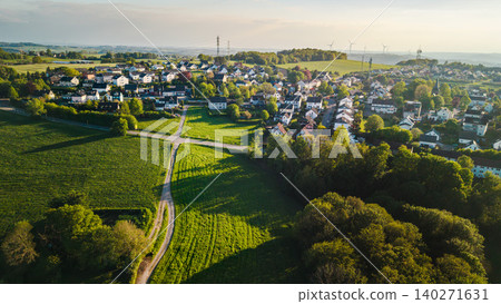 Aerial panorama of peaceful small town in western Germany with green farmland and residential houses during golden sunset hour 140271631