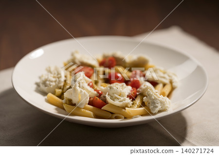 Penne pasta with mozzarella, pesto and fresh cherry tomatoes Penne pasta with mozzarella, pesto and fresh cherry tomatoes 140271724