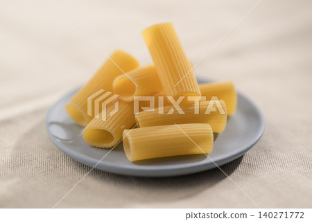 Dry rigatoni pasta on a saucer before cooking 140271772