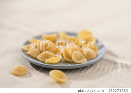 Dry Orecchiette pasta on a saucer before cooking Dry Orecchiette pasta on a saucer before cooking 140271783