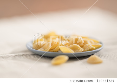 Dry Orecchiette pasta on a saucer before cooking Dry Orecchiette pasta on a saucer before cooking 140271785