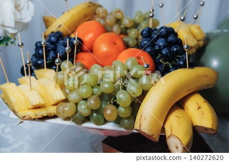 Fresh fruit platter with bananas, grapes, oranges, and pineapple slices Fresh fruit platter with bananas, grapes, oranges, and pineapple slices 140272620