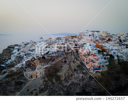 A breathtaking aerial view of the whitewashed village of Oia, Santorini, showcasing luxury resorts with infinity pools overlooking the Aegean Sea. A stunning blend of Cycladic architecture A breathtaking aerial view of the whitewashed village of Oia, Santorini, showcasing luxury resorts with infinity pools overlooking the Aegean Sea. A stunning blend of Cycladic architecture 140272657