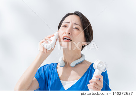 夏天,一位女士正在使用冰圈和手持風扇。 夏天,一位女士正在使用冰圈和手持風扇。 140272687