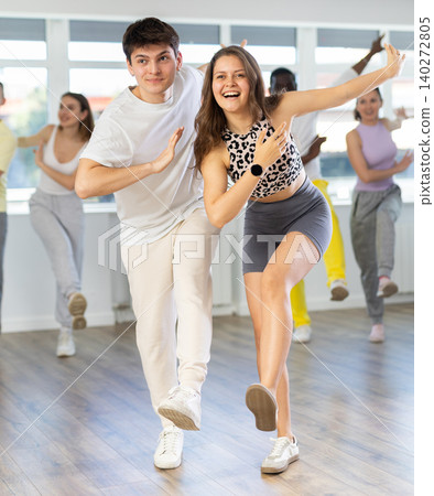 Young woman dances incendiary boogie woogie with man partner during choreography lesson Young woman dances incendiary boogie woogie with man partner during choreography lesson 140272805