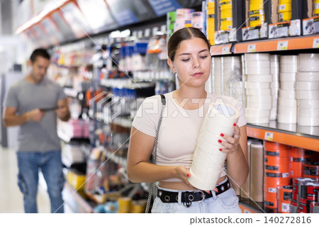 Female customer woman buying masking tape in hardware store Female customer woman buying masking tape in hardware store 140272816