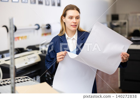Print worker controlling printing process on modern offset machine in print shop Print worker controlling printing process on modern offset machine in print shop 140272838