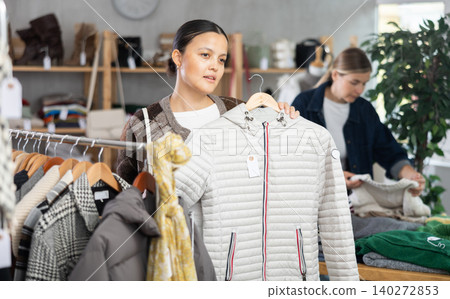Adult woman choosing down jacket in clothing store 140272853