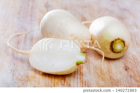 Whole and halved white radishes 140272863