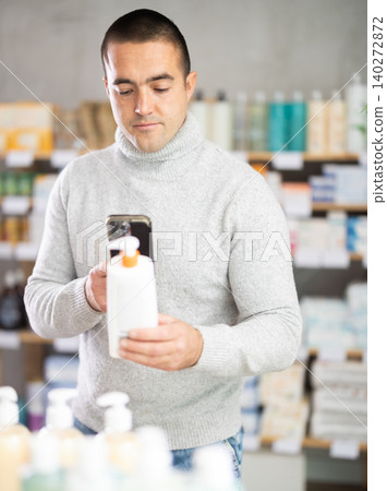 Man in pharmacy scans QR code on emollient for sensitive skin 140272872